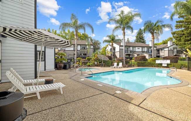 a swimming pool with palm trees in front of a house