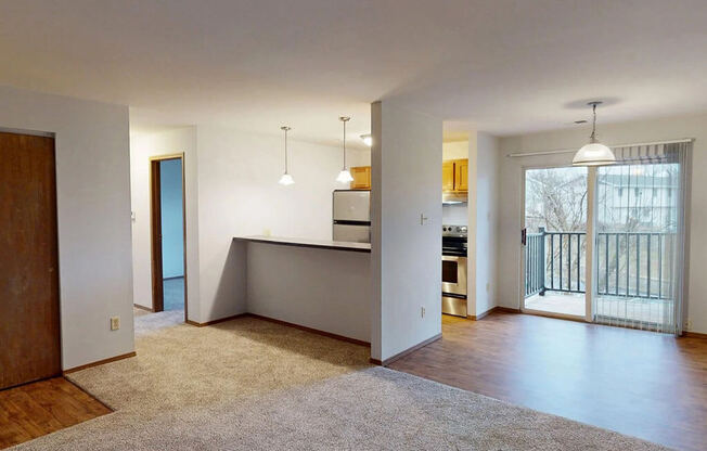 A spacious living room with a kitchen area in the background.