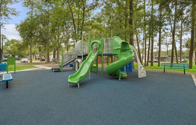 A playground with a green slide in a park