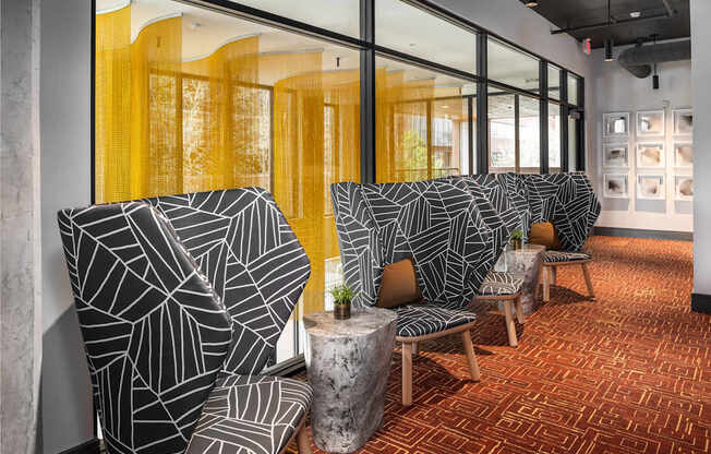 A room with two chairs and a table with a plant on it.