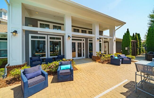 a patio with blue chairs and a building with windows