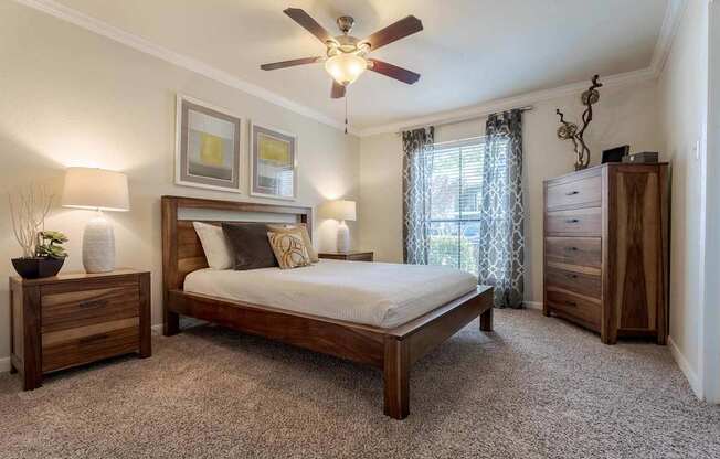 A bedroom with a bed, nightstand, and dresser.