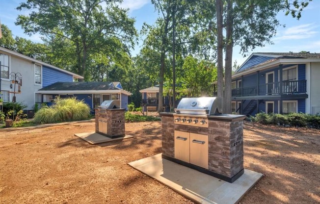 a backyard with a barbecue grill in front of a house