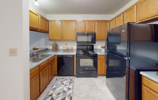 a kitchen with black appliances and wooden cabinets