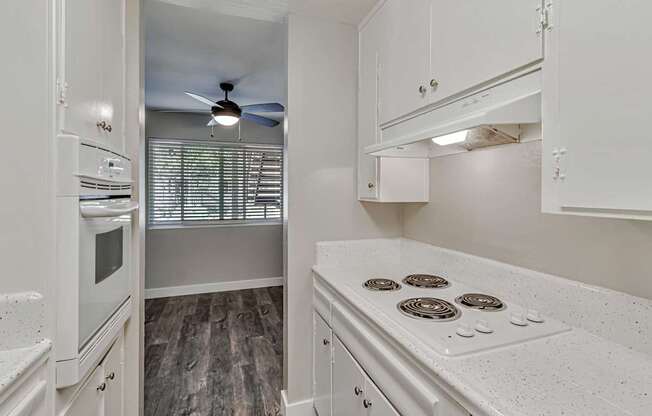 A white kitchen with a stove top oven and a microwave.