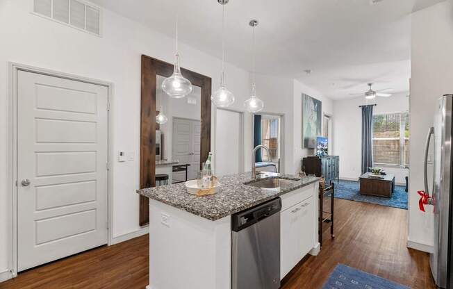 A kitchen with a granite countertop and stainless steel appliances.