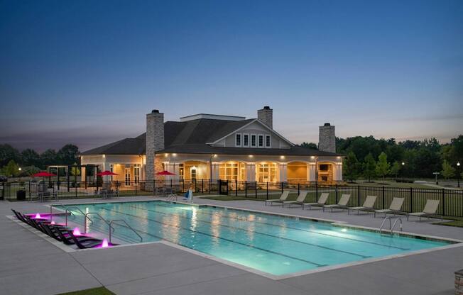 A large house with a pool in front of it.