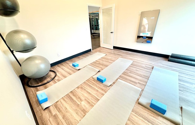 A yoga studio with mats and blocks on the floor.