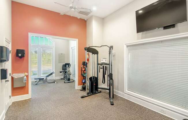a home gym with exercise equipment and a tv at Lagniappe of Biloxi Apartment Homes, Biloxi, MS, 39532