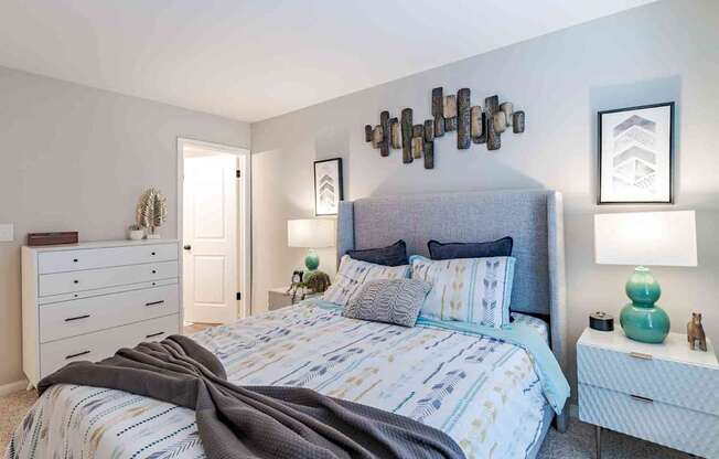 A bedroom with a large bed and a dresser.