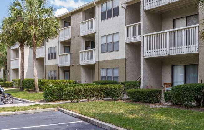 an apartment building with balconies and palm trees