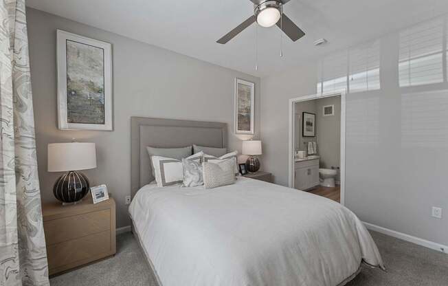 A bedroom with a large bed and a ceiling fan.