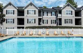 an apartment building with a large swimming pool at Magnolia Pointe Apartments in Duluth, GA