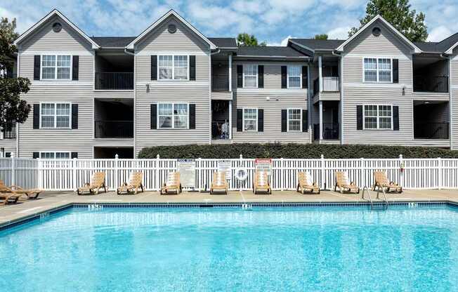 an apartment building with a large swimming pool at Magnolia Pointe Apartments in Duluth, GA