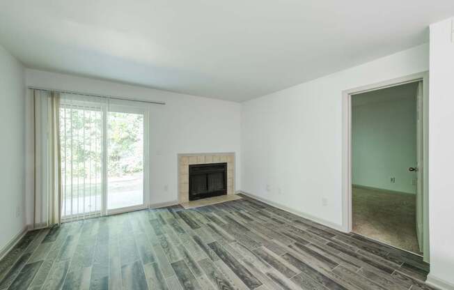 Updated living room with a fireplace and sliding glass doors.