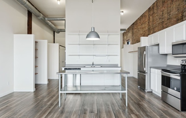 a kitchen with white cabinetry and stainless steel appliancesat Gaar Scott Historic Lofts, Minnesota