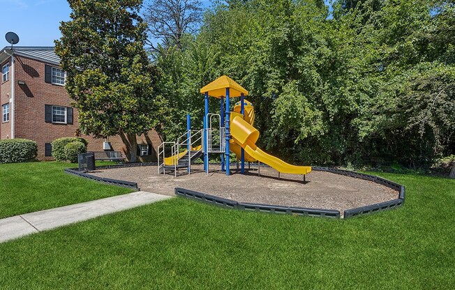 a playground in a yard with a yellow swing set