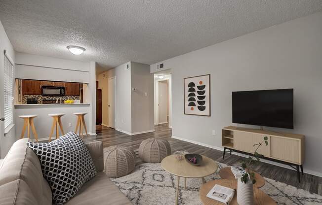 a living room with a couch and a coffee table in front of a flatscreen tv