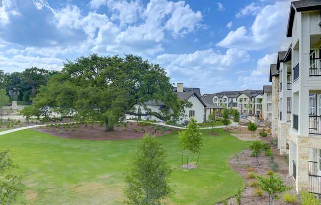 an aerial view of an apartment complex with a green lawn and trees at Legacy at Cibolo, Texas