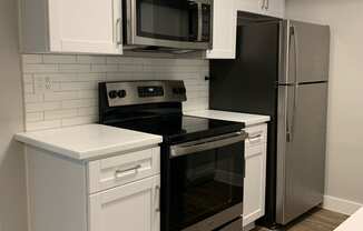 a kitchen with stainless steel appliances and white cabinets