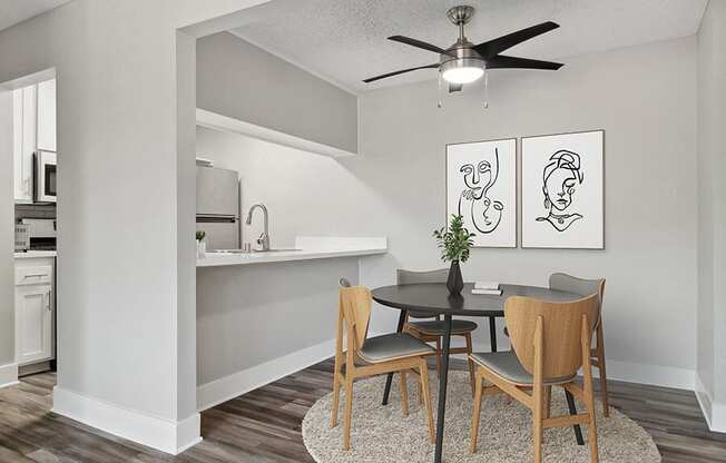 Model Dining Room with Wood-Style Flooring and View of Kitchen at Fullerton Hills Apartments located in Fullerton, CA.