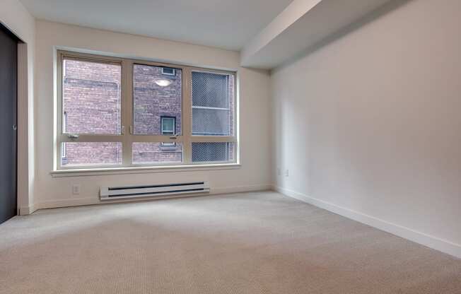 A room with a window and a radiator on the wall.