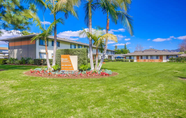 a building with palm trees and a sign in the grass