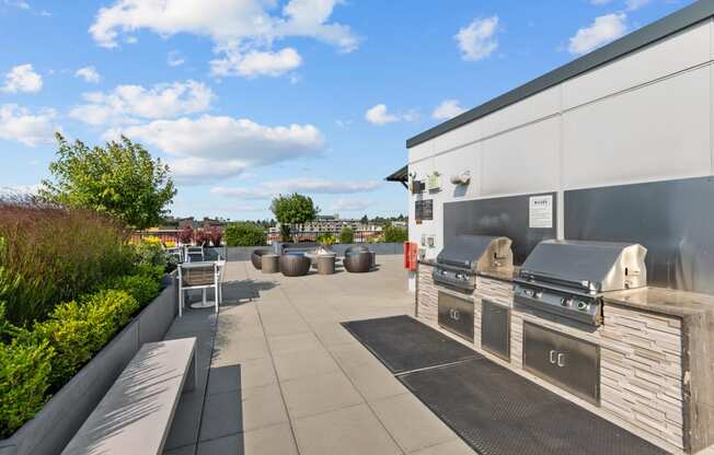 the outdoor patio of a home with a barbecue grill and seating