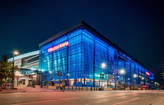 The Rocket Arena is a large, modern building with a glass facade and is lit up at night.