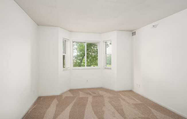 an empty room with carpet and a window