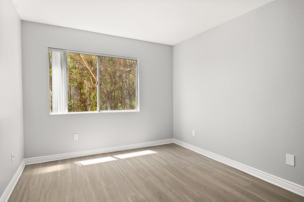 an empty room with wooden floors and a window at NOHO GALLERY Apartments, California