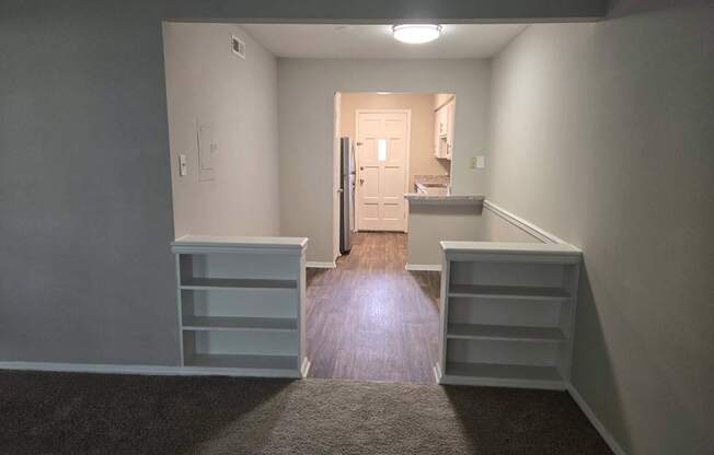 A room with a grey carpet and a white door.