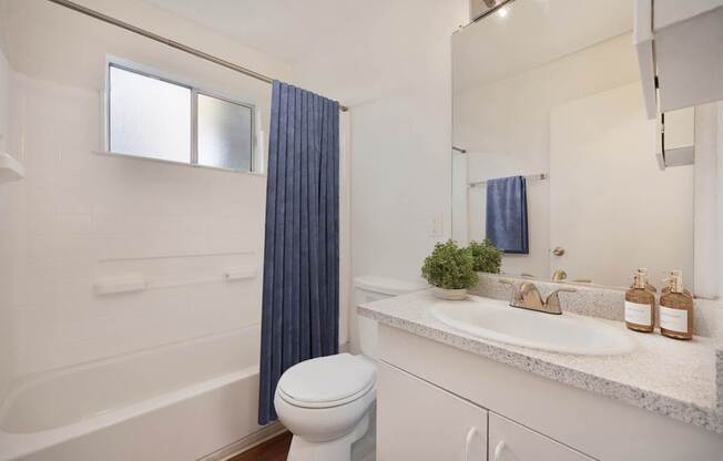 A white bathroom with a white toilet and a white sink.