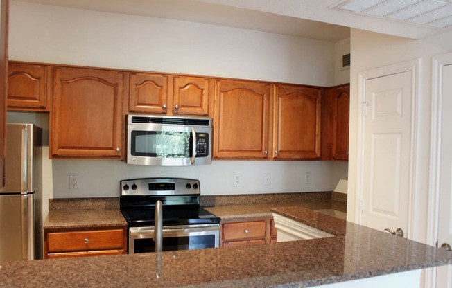 a kitchen with granite counter tops and wooden cabinets