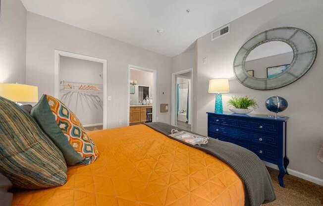 A bedroom with a bed, dresser, and mirror.