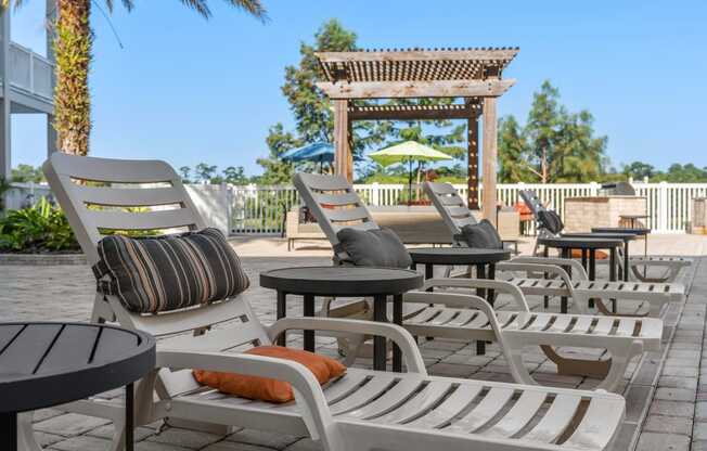 a group of lounge chairs and tables on a patio