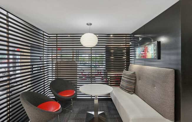 A modern living room with a grey couch, two chairs and a table.
