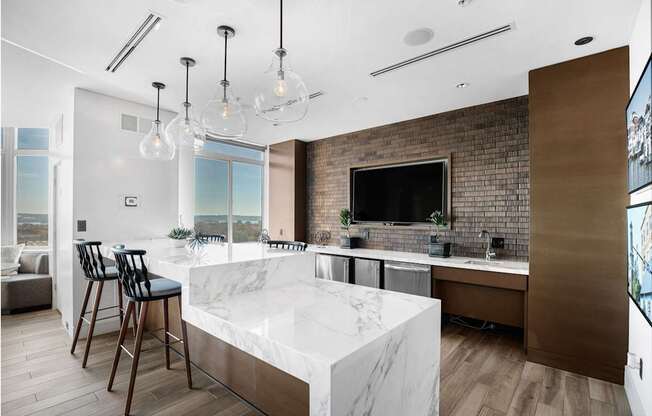 A modern kitchen with a marble countertop and a brick accent wall.