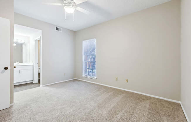 A room with a ceiling fan and carpeted floor.