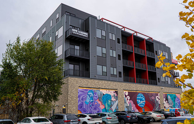 exterior image of an apartment building with a colorful mural on the side