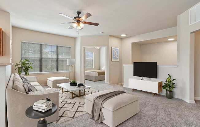 A living room with a ceiling fan and a flat screen TV.