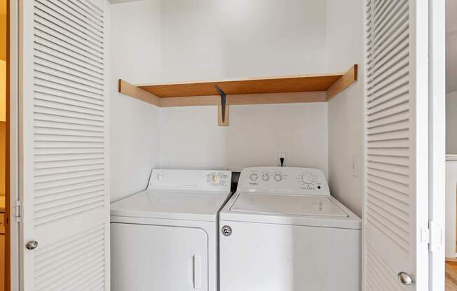 a washer and dryer in a laundry room with white walls