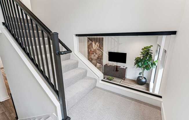 A staircase with a carpeted floor and a black railing.