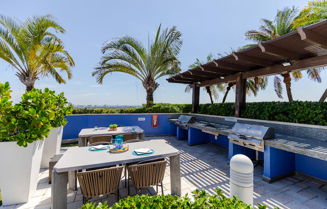 a patio with tables and chairs and a grill