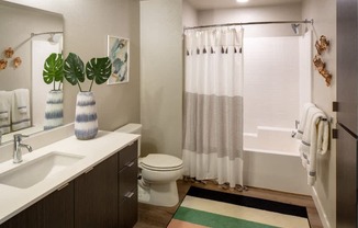 A bathroom with a white sink, toilet, and shower curtain.