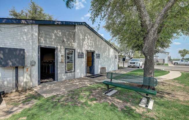 a gray building with a green bench in front of it