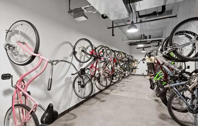 a row of bikes hanging on a wall in a bike shop