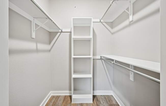 A spacious walk in closet with white shelves at Windridge On The Parkway Apartments in Dallas, TX