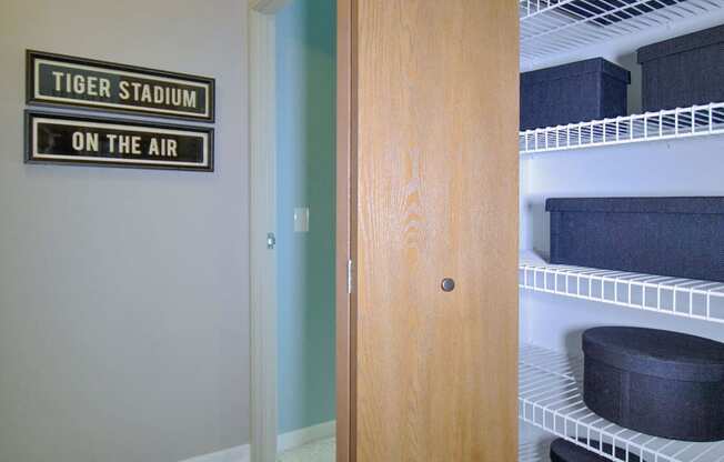 a walk in closet with a tiger stadium on the air sign