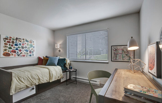 a bedroom with a bed and a desk with a chair